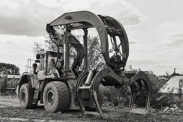 dual function grapple skidder stands on the ground outdoors