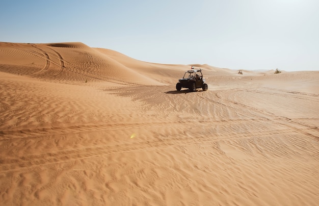 Photo dubai al awir desert with wheels traces and riding buggy quad bike at heat