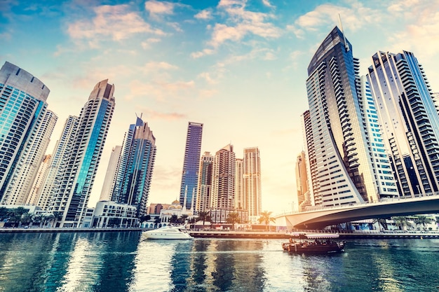 Dubai marina and tourist boat at sunset Highrise residential buildings business skyscrapers