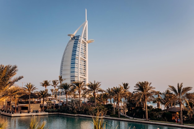 Dubai uae 04 november 2021 het uitzicht op het burj al arab hotel vanaf madinat jumeirah in dubai bij zonsondergang luxe moderne architectuur en toeristisch concept