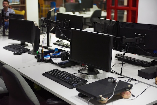 dubbel beeldscherm en laptopcomputer op modern kantoor binnenshuis, startup bedrijfssoftware ontwikkelt technologie