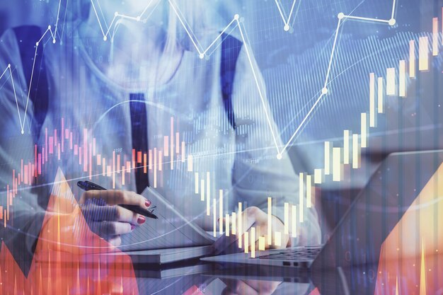 Dubbele blootstelling van zakenvrouw handen typen op computer en financiële grafiek hologram tekening Stock market analysis concept