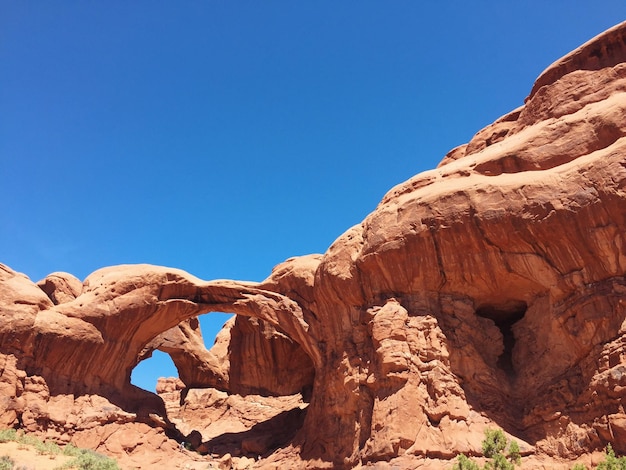 Dubbele boog tegen een heldere blauwe hemel in het Arches National Park