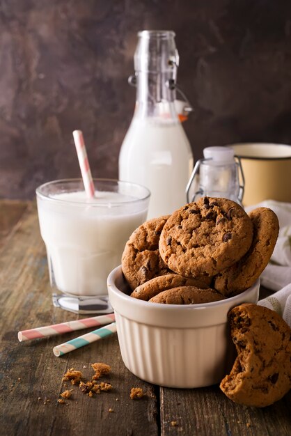 Dubbele chocoladekoekjes met spaanders op een kom en melk in glas