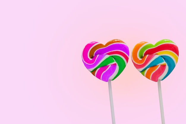 Dubbele mooie het suikergoedstok van hartlollies op roze achtergrond