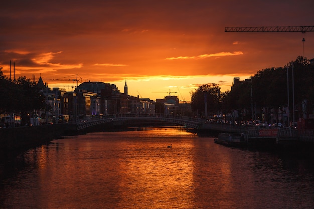 Foto il paesaggio urbano di dublino durante un colorato tramonto con nuvole e gabbiani sul fiume liffey