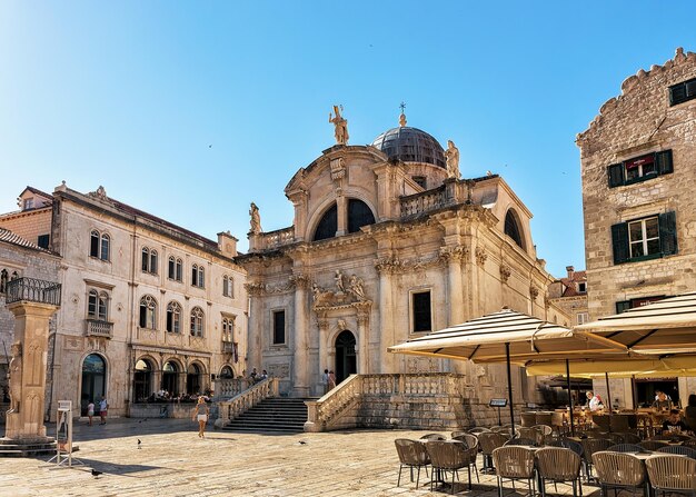 Dubrovnik, Croatia - August 19, 2016: People and terrace cafe on the Square at St Blaise Church in Stradun Street in the Old city of Dubrovnik, Croatia