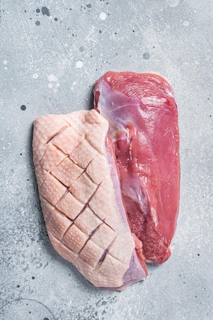 Duck breast fillet on butcher table raw poultry meat Gray background Top view