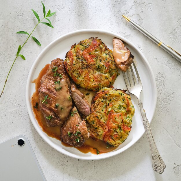 Duck breast in sauce with vegetable cutlets.