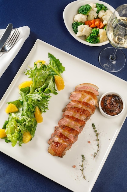 Duck breast with fruit sauce on white plate