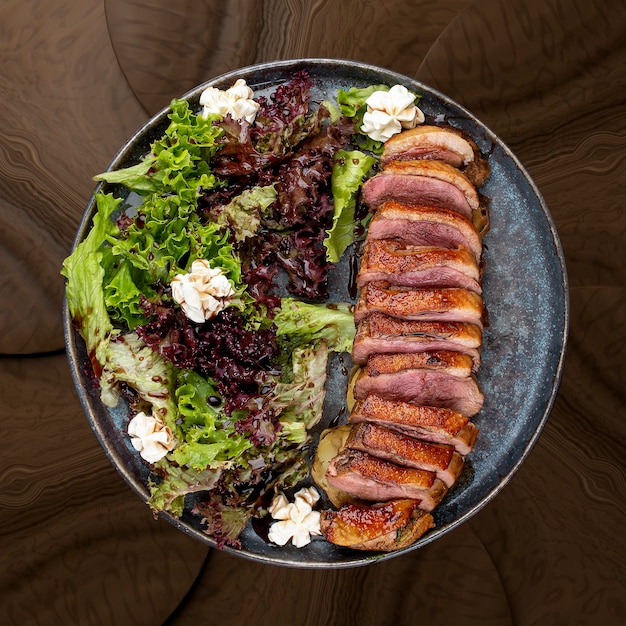 Duck breast with lettuce and cream cheese On a wooden background