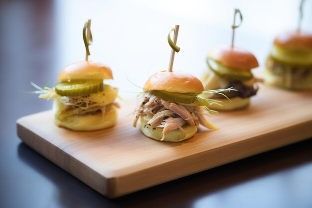 Duck confit slider with pickles on a wooden serving tray