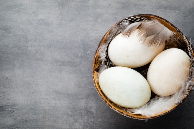 Duck eggs on a cage gray background.