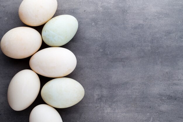 Duck eggs on a cage gray background.