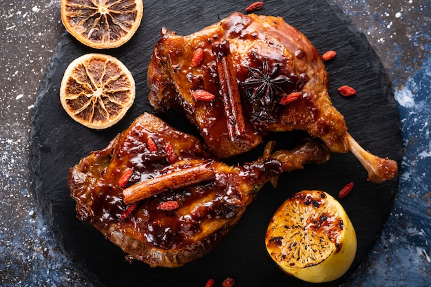 Duck leg confit with rice and goji berries. Traditional french cuisine. View from above.