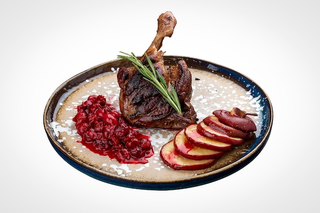 Duck leg with winecherry sauce and baked apple On a white background