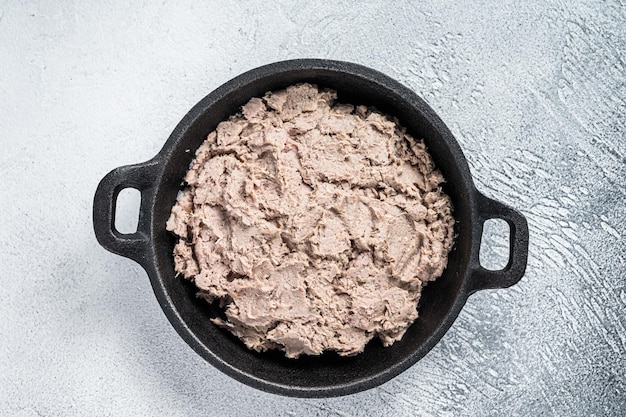 Duck pate Rillettes de Canard in a pan. White background. Top View.  Copy space.