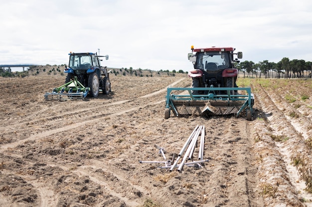 Due to drying and spoiling, agricultural machinery is operating on the field.