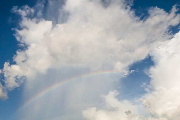 Duidelijke hemel met wolken en rianbow, blauwe achtergrond