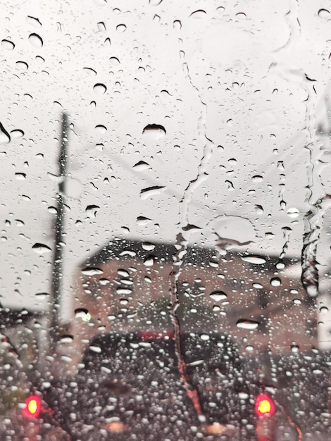 Foto duidelijke waterdruppels op de voorruit van de auto na de regen terwijl de verkeersopstopping
