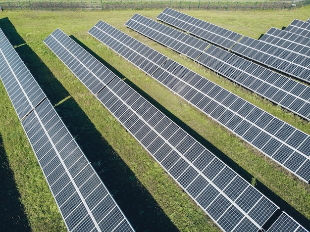 Duidelijke zonnepanelen in een veld op een rij. Uitzicht vanaf de drone. Zonnepanelen onder de zon. Energieconcept