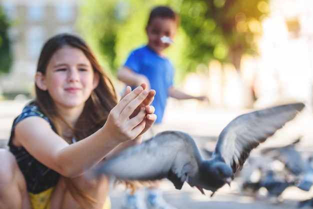 Duif vliegt uit de handen van een klein meisje Kinderen spelen met duiven