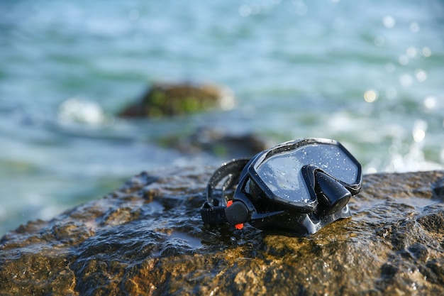 Duikbril op de steen bij de zee