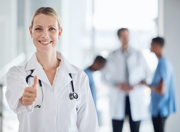 Foto duim omhoog glimlach en gelukkige dokter vrouw of succes in een medisch ziekenhuis portret zoals gebaar of stem handen oke of succes welkom of motivatie hand communicatie icoon of bedankje