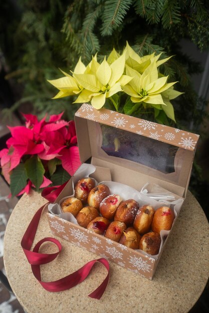 Duitse donuts berliner met vulling en poedersuiker in een doos op een bruine stenen tafel Op kerstversiering achtergrond