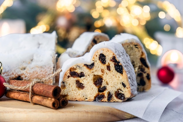 Duitse Stollen cake traditioneel Europees dessert met gedroogde vruchten rozijnen noten en marsipan kersttaart met kaneel en kerstverlichting op de achtergrond Recept van zelfgemaakt dessert voor de feestdagen