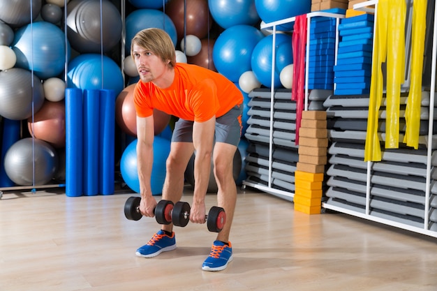 Dumbbell deadlift blonde man op sportschool Gewichtheffen