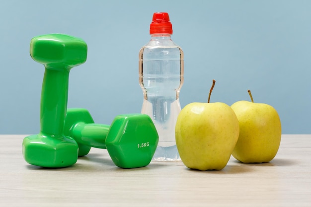 Dumbbells and different tools for fitness on floor in room