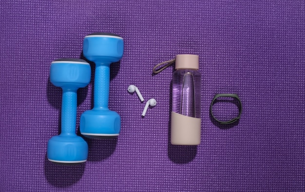 Dumbbells and fitness accessories on a fitness mat. Flat lay composition