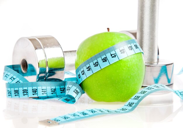 Dumbbells with an apple on a white background. A healthy way of life