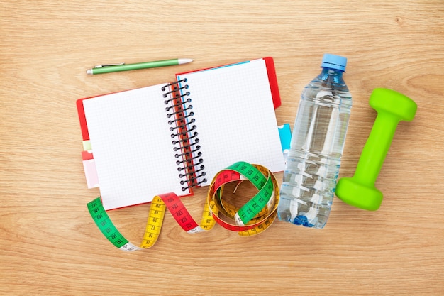 Dumbells, tape measure, water bottle and notepad for copy space. Fitness and health