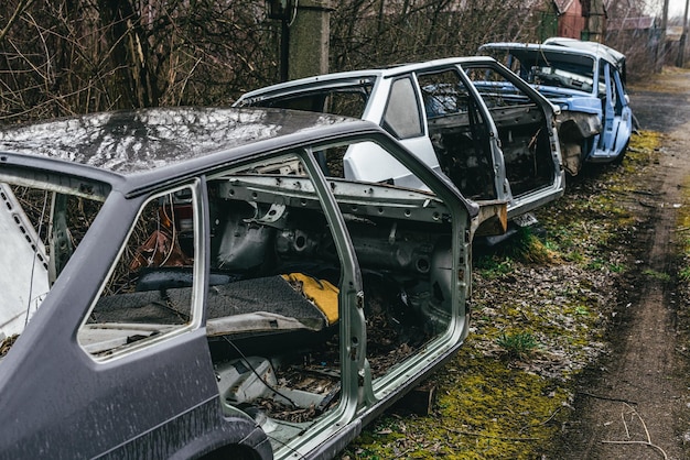 A dump of broken rusted cars their parts and tires