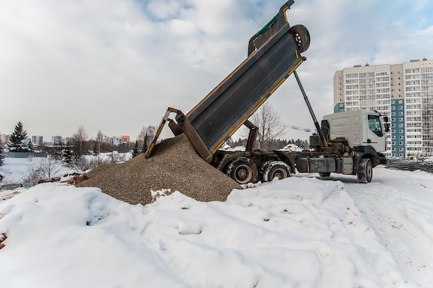 Foto l'autocarro con cassone ribaltabile scarica il carico in un cantiere edile