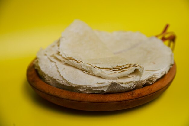 Dumpling skin or dimsum in a wooden bowl on a yellow background