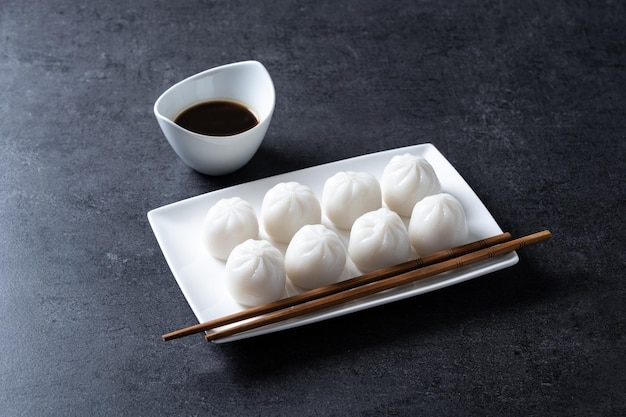 Dumplings in bamboo steamer on black stone background