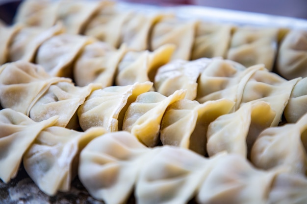 Foto dumplings gevuld met vlees, ravioli, dumplings. knoedels met vulling. bolingrediënten, chinese keuken