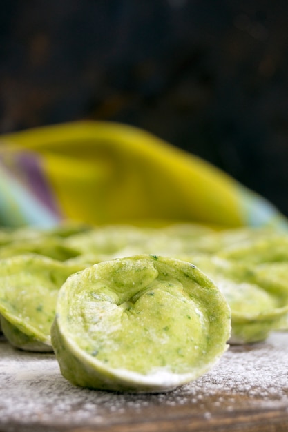 Dumplings green on a black background in flour.