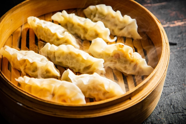 Foto gyoza di gnocchi in un vapore di bambù con vapore caldo