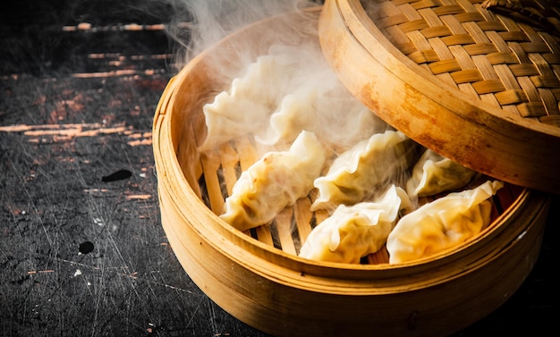 Foto dumplings gyoza in een bamboestomer met hete stoom