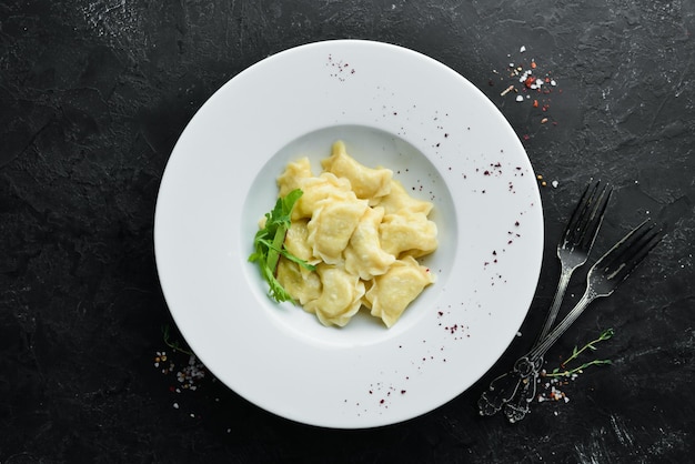 Dumplings met aardappelen, boter en zure room. Oekraïense traditionele keuken. Bovenaanzicht. Vrije ruimte voor uw tekst.