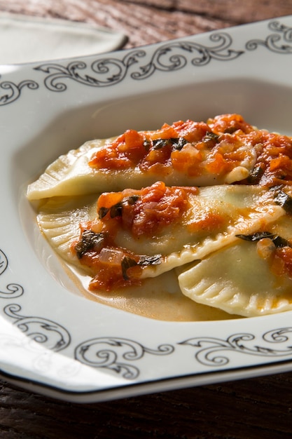 Dumplings met vlees met tomaat op een bord - pierogi