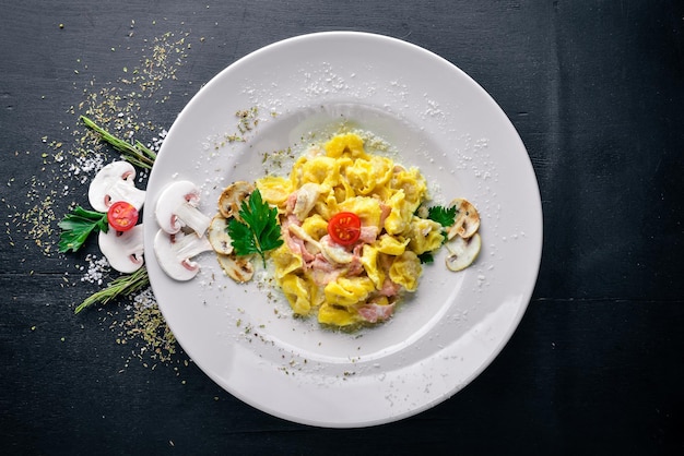 Пельмени в грибном и сливочном соусе Традиционная итальянская еда На деревянном фоне Вид сверху Свободное место для текста