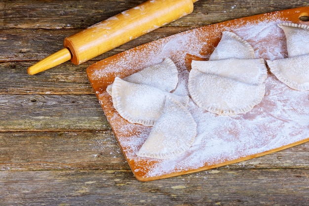 Dumplings raw on a wooden board. Traditional homemade food. 