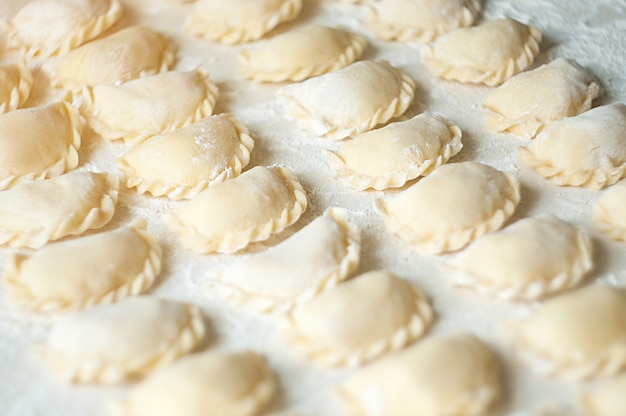 Dumplings (vareniki) met aardappelen - traditionele oekraïense gerechten. het koken van rauwe knoedels met aardappelen