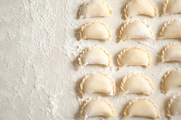 Dumplings (vareniki) with potatoes - traditional Ukrainian food. Cooking raw dumplings with potatoes