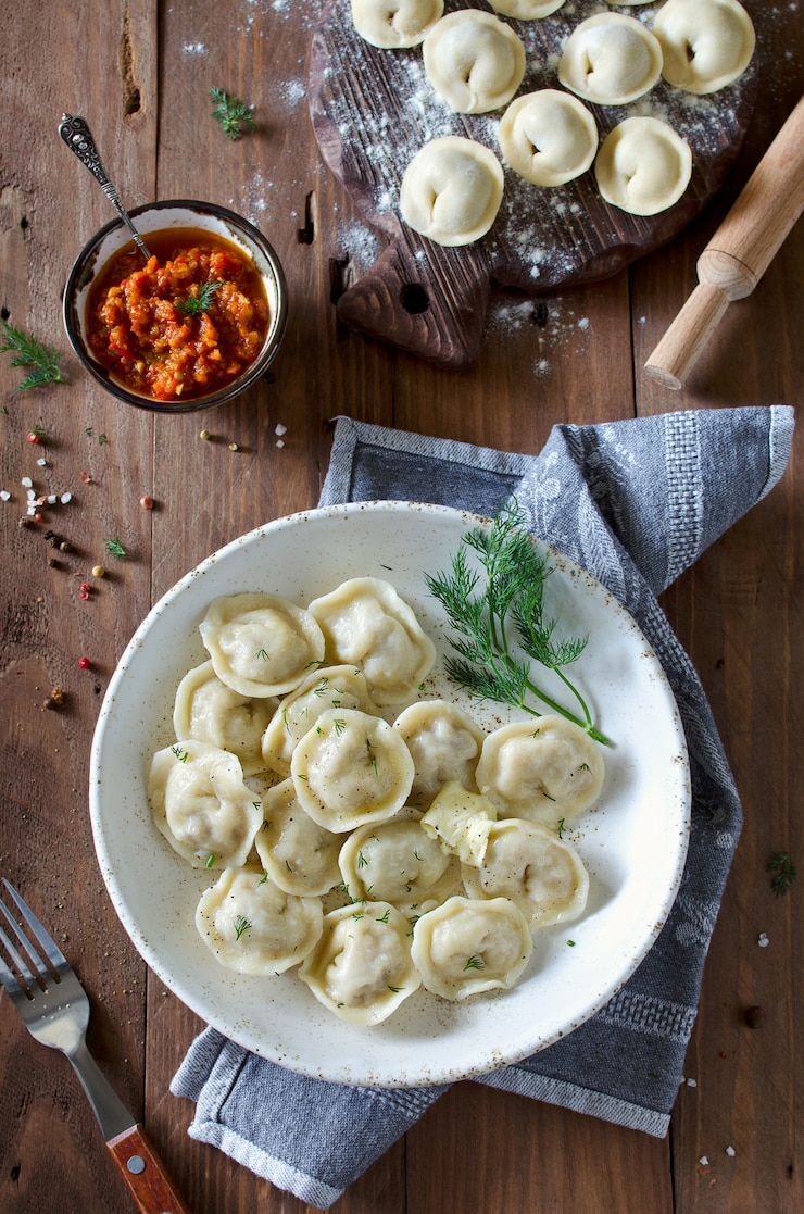 Фотография пельмени с мясом, приправленные перцем и укропом
